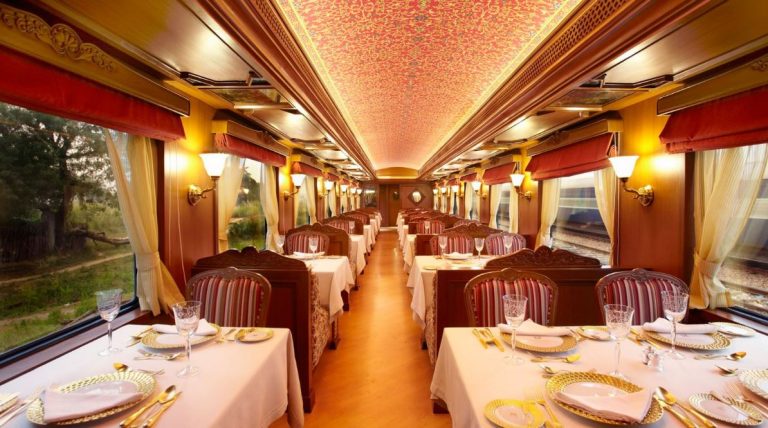 Voiture restaurant du Maharajas Express avec tables dressées, vaisselle dorée et décor royal indien