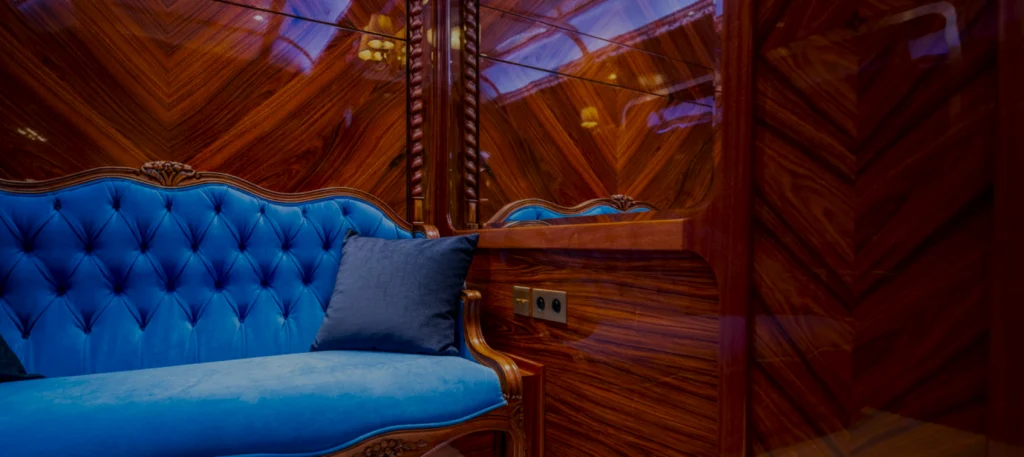 Cabine Grand Tour France Train avec canapé velours bleu capitonné et boiseries acajou luxueuses