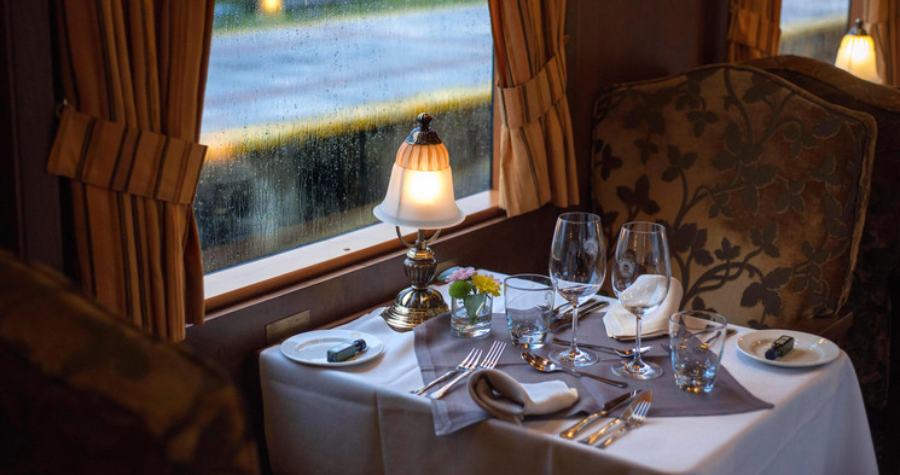 Voiture-restaurant du Costa Verde Express avec tables dressées en nappes blanches et boiseries chaleureuses