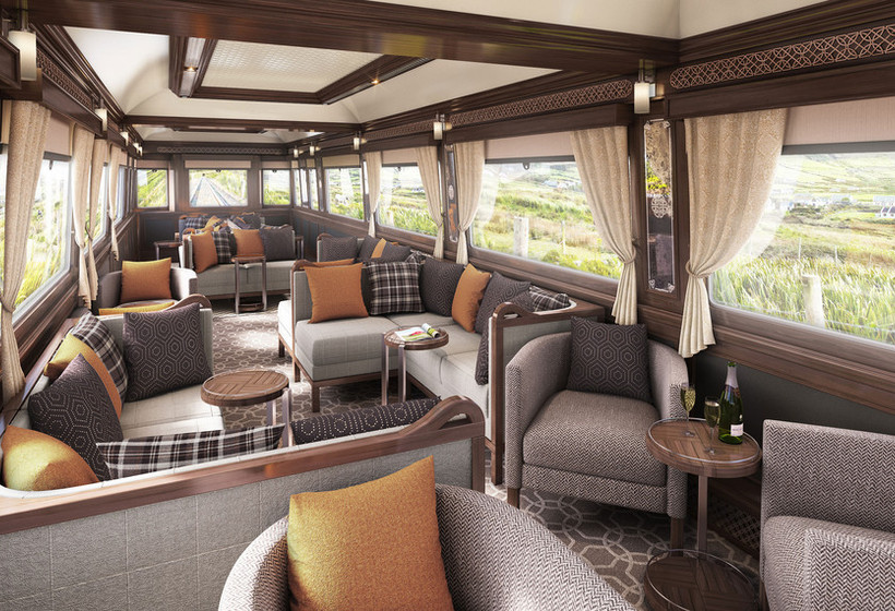 Voiture d'observation Kildare du Belmond Grand Hibernian — salon avec fauteuils gris, coussins orangés et boiseries géorgiennes