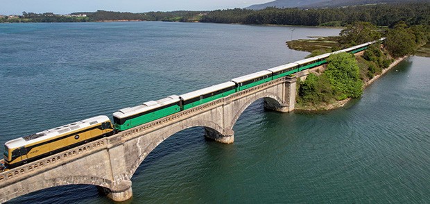 Costa Verde Express franchissant un viaduc au-dessus d'un lac de montagne dans le nord de l'Espagne