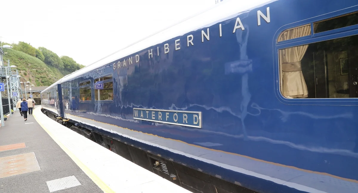 Voiture Waterford du Belmond Grand Hibernian — livrée bleu nuit et argent, train de luxe irlandais à quai