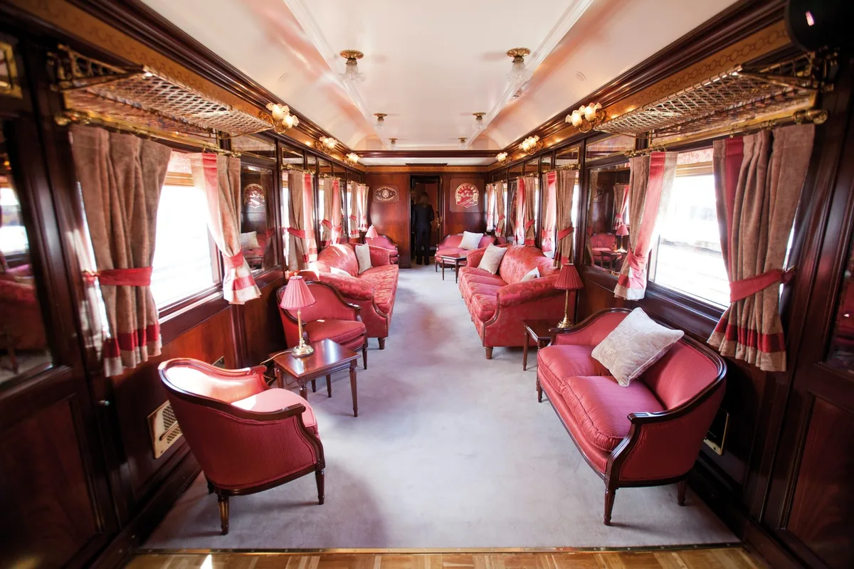 Voiture-salon Belle Époque du train Al Andalus avec banquettes en velours rouge et boiseries d'origine