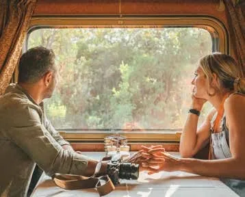 Couple romantique regardant par la fenêtre d'un train de luxe en Australie, Great Southern Railway