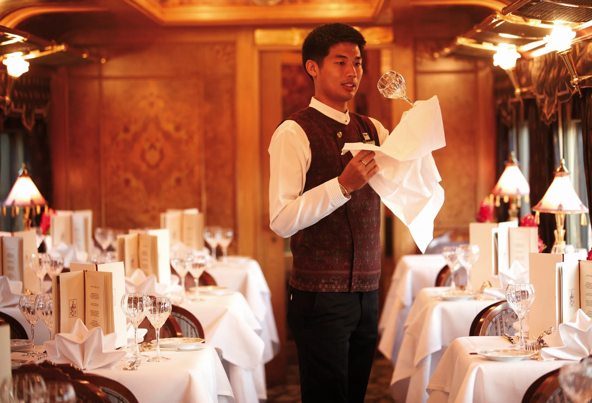 Steward préparant le service dans le wagon-restaurant élégant de l'Eastern Oriental Express