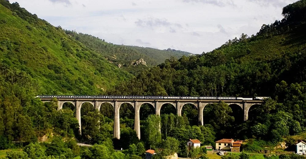 El Transcantabrico Gran Lujo traversant un viaduc dans les forêts du nord Espagne