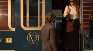 Embarquement de voyageurs élégants dans le Orient Express, train de luxe, avec steward accueillant les passagers à la porte