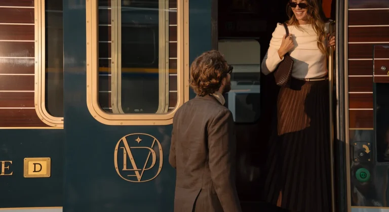 Embarquement de voyageurs élégants dans le Orient Express, train de luxe, avec steward accueillant les passagers à la porte
