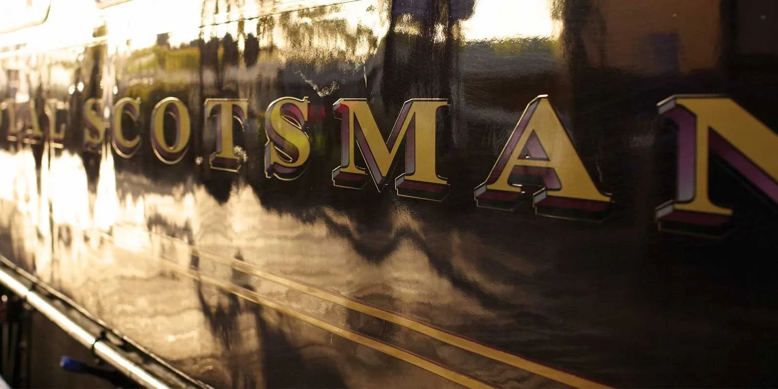 Logo Royal Scotsman en lettres dorées sur la caisse bordeaux du train de luxe écossais en gare d'Édimbourg