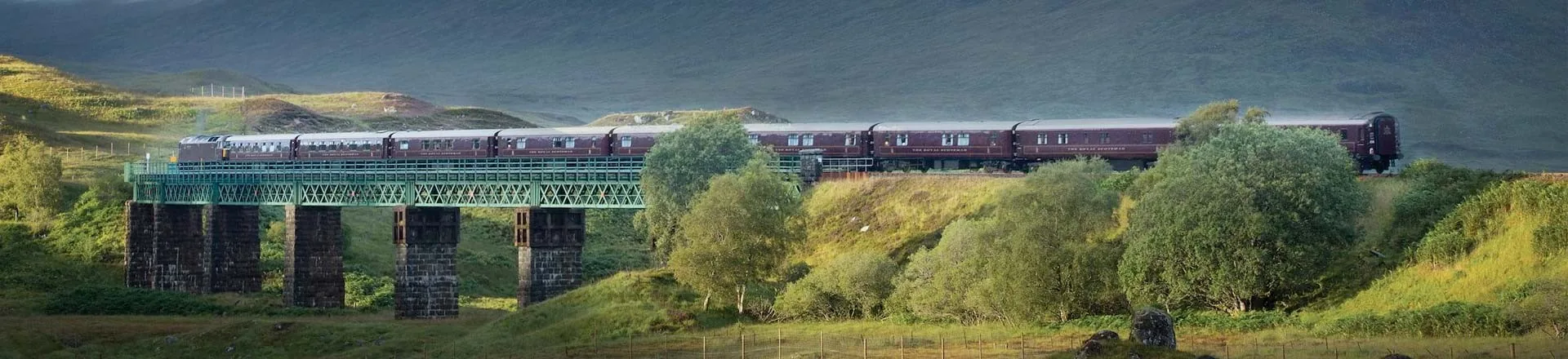 Belmond Royal Scotsman sur un viaduc des Highlands — train de luxe Écosse sur fond de montagnes vertes