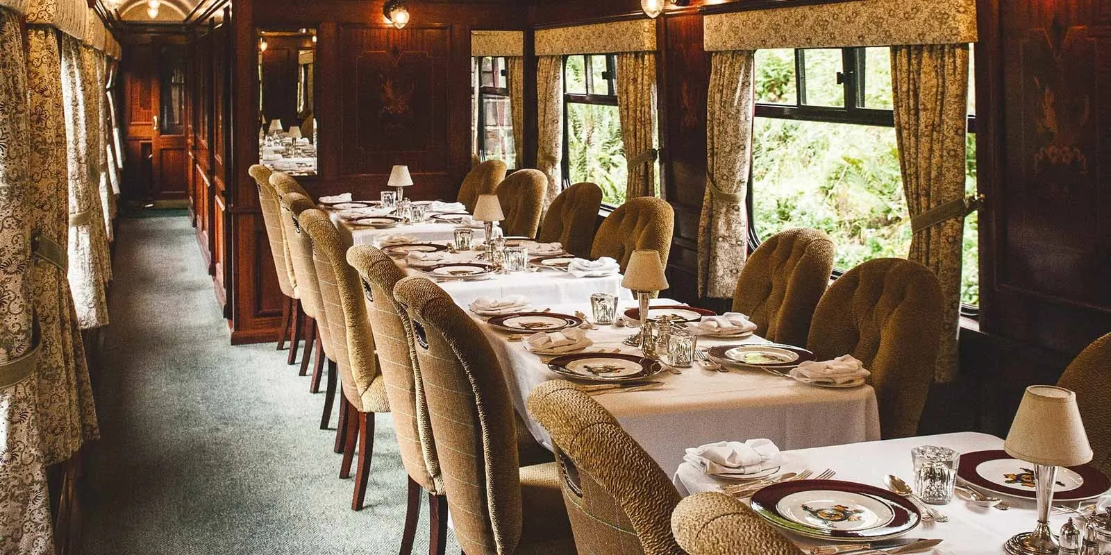 Wagon restaurant du Belmond Royal Scotsman dressé pour le dîner gastronomique — nappes blanches, argenterie et bougeoirs