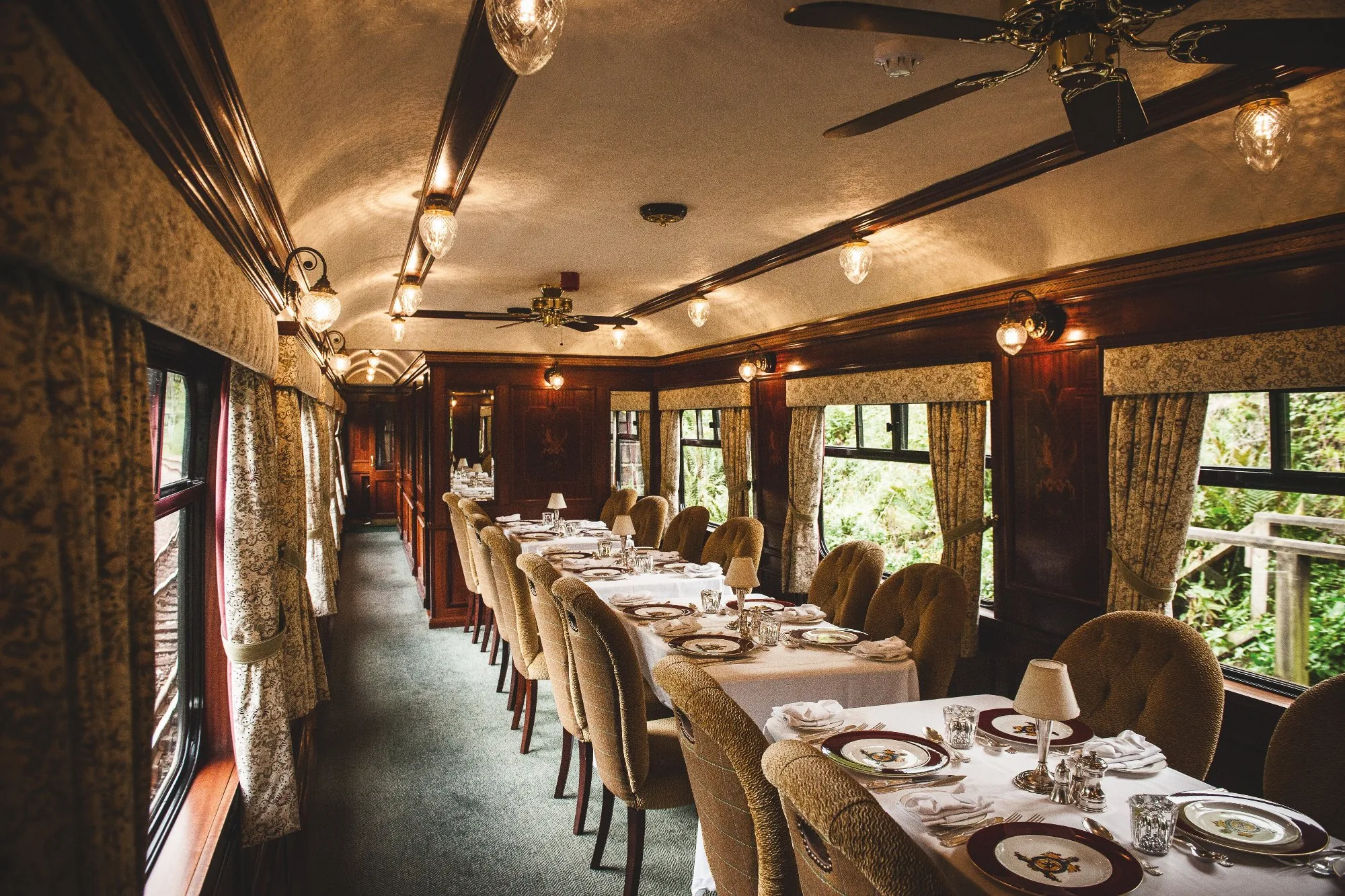Service gastronomique dans le wagon restaurant du Royal Scotsman — steward en gilet tartan apportant les plats