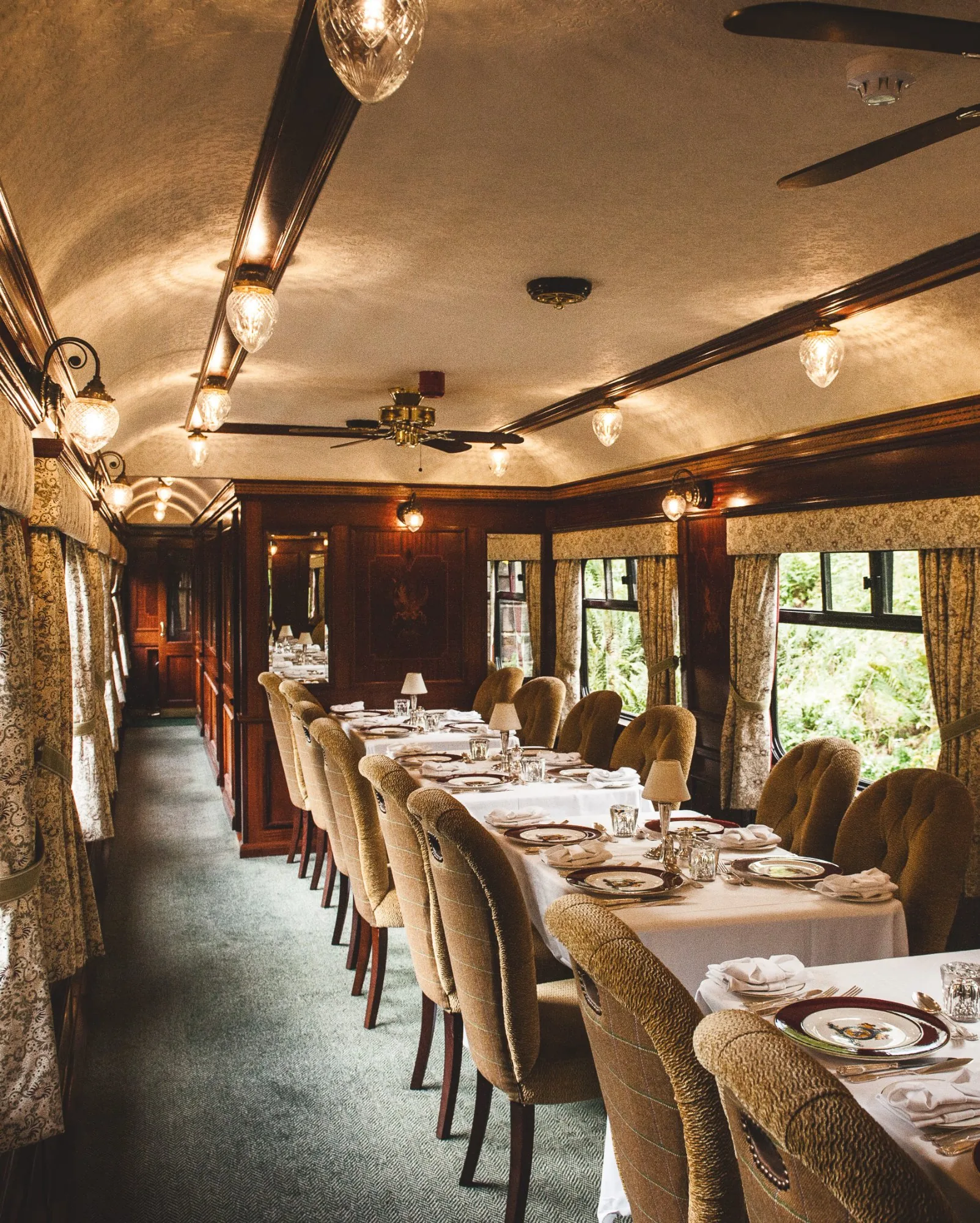 Restaurant Swift du Belmond Royal Scotsman — élégance ferroviaire écossaise avec boiseries et éclairage tamisé