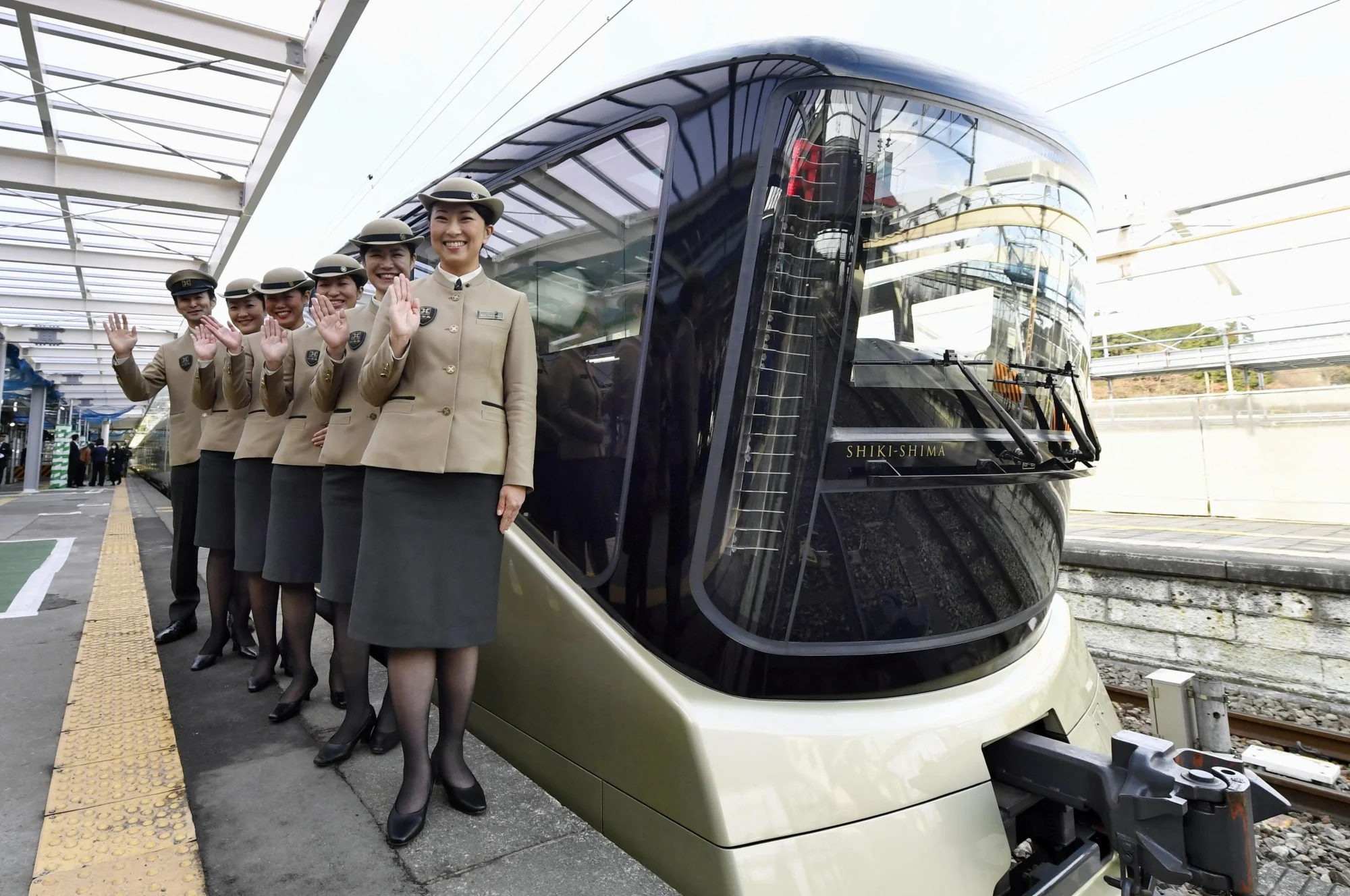 Personnel du Train Suite Shiki-Shima en uniforme kaki sur le quai d'Ueno — accueil des 34 passagers privilégiés