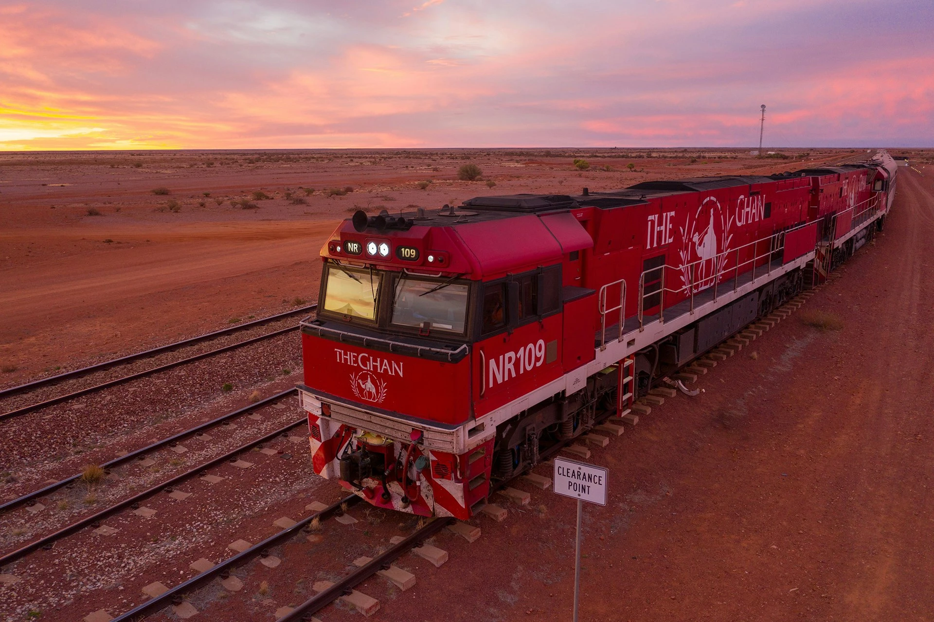 Locomotive rouge de The Ghan au coucher du soleil dans l'outback australien