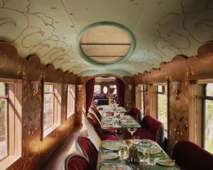 Voiture Celia du British Pullman - Restaurant luxe avec décoration art déco, chaises velours bordeaux et tables dressées
