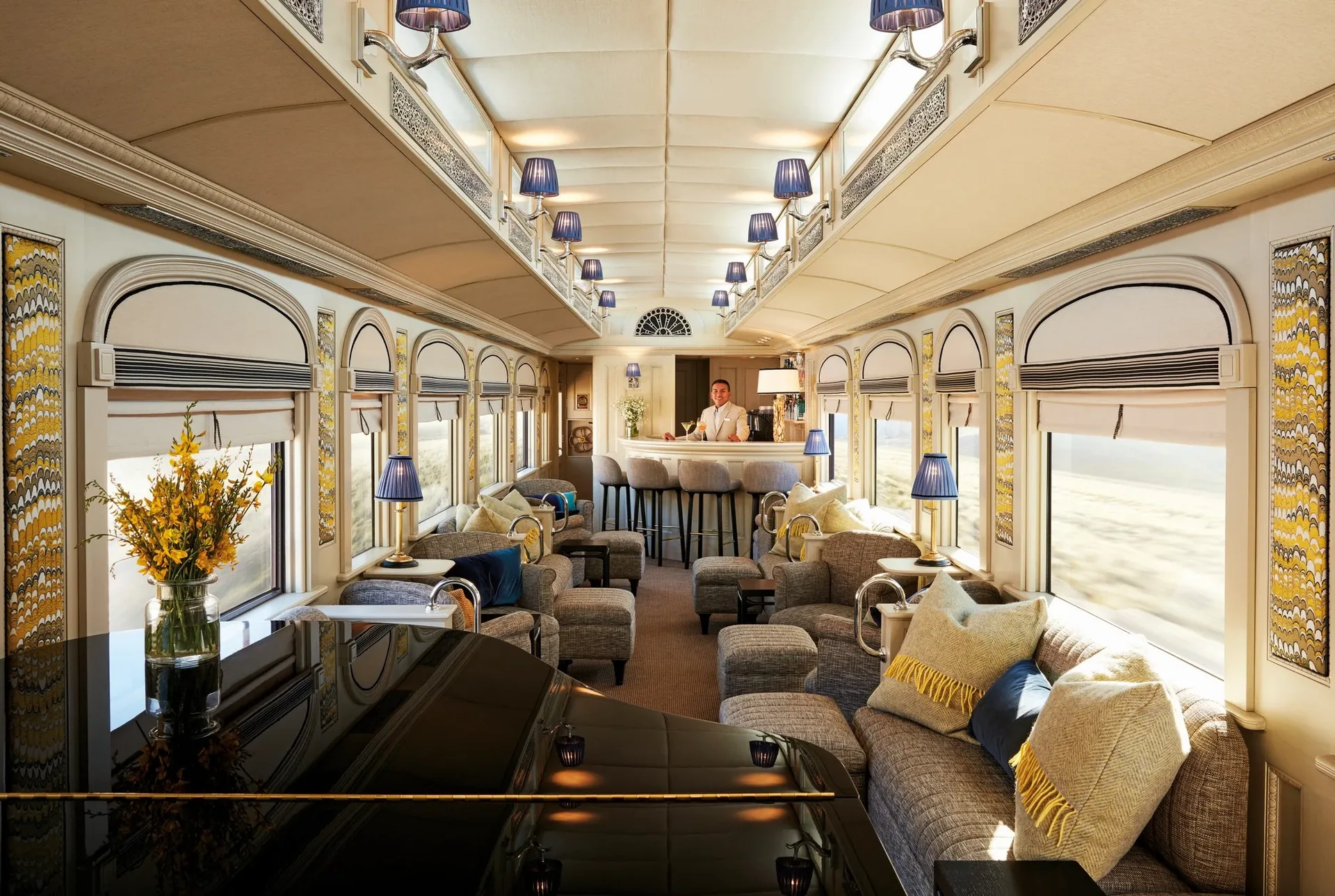 Wagon-bar lounge du Belmond Andean Explorer — lampes bleues, désert péruvien en arrière-plan