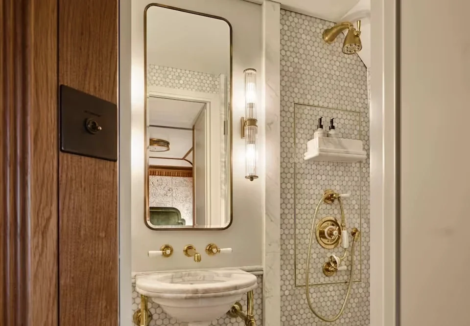 Salle de douche en marbre avec robinetterie dorée — cabine double Britannic Explorer