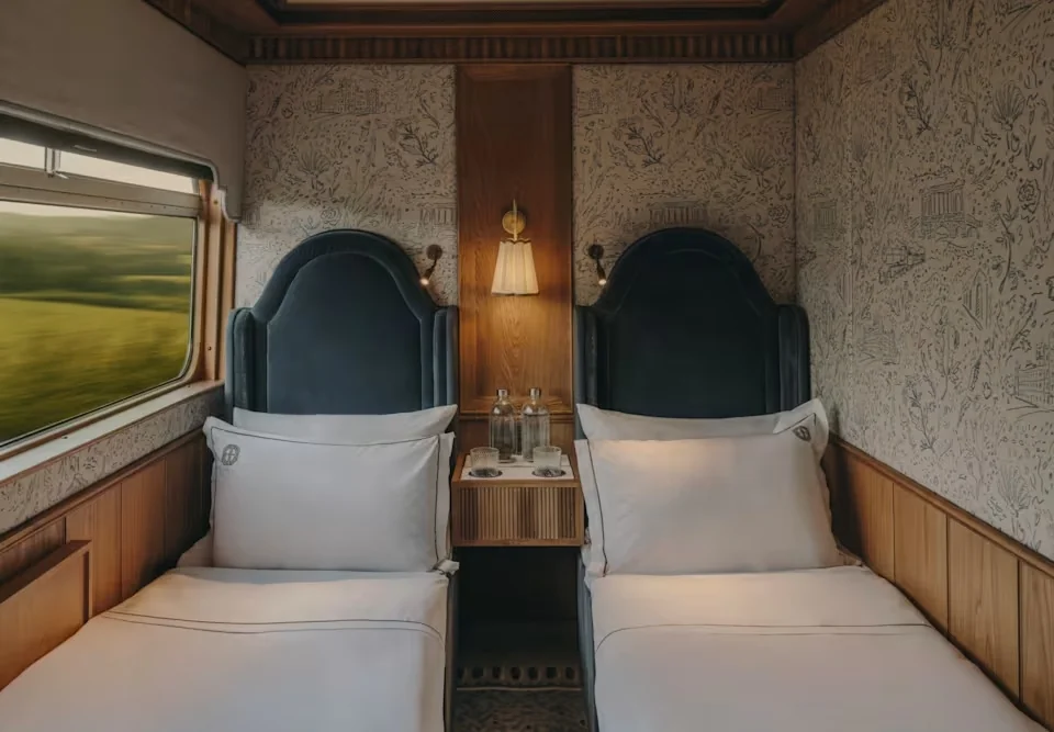 Cabine twin du Britannic Explorer Belmond avec lits jumeaux et têtes de lit velours bleu