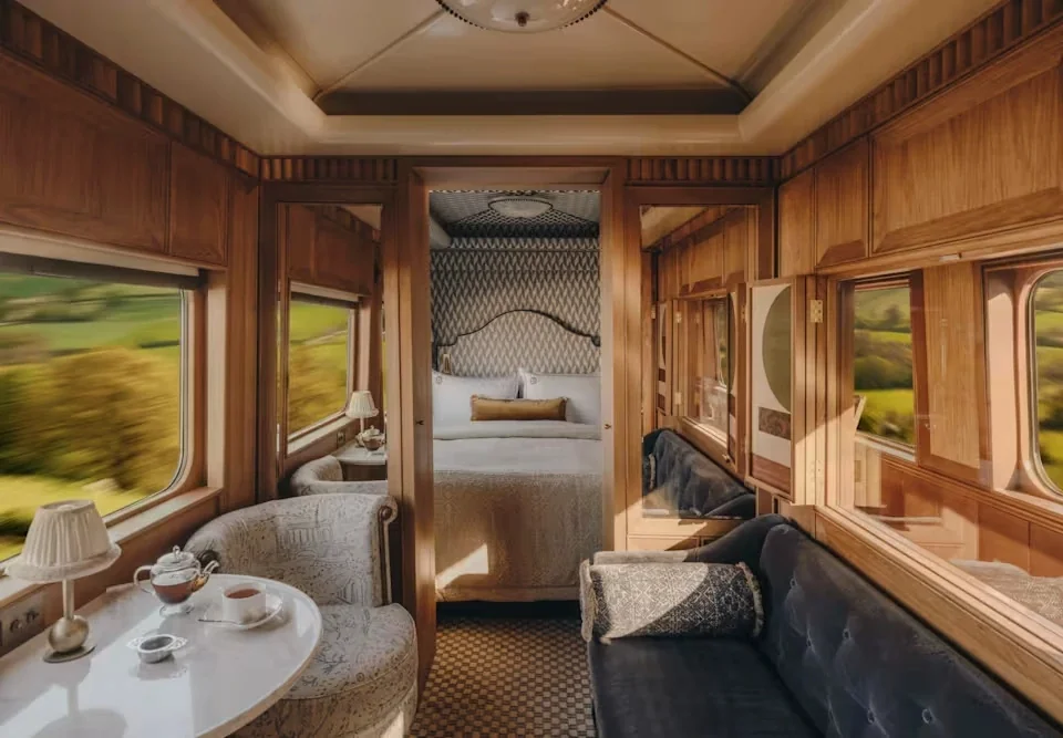 Grand Suite Juniper du Britannic Explorer — canapé velours bleu et boiseries chaudes