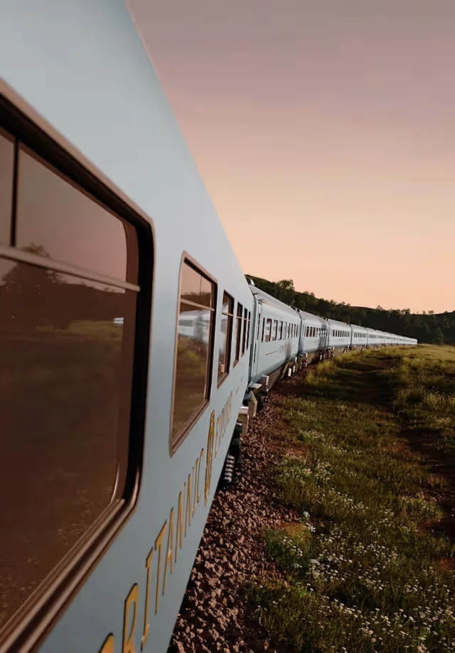 Train Britannic Explorer Belmond en mouvement au crépuscule — livrée bleu clair et lettrage doré