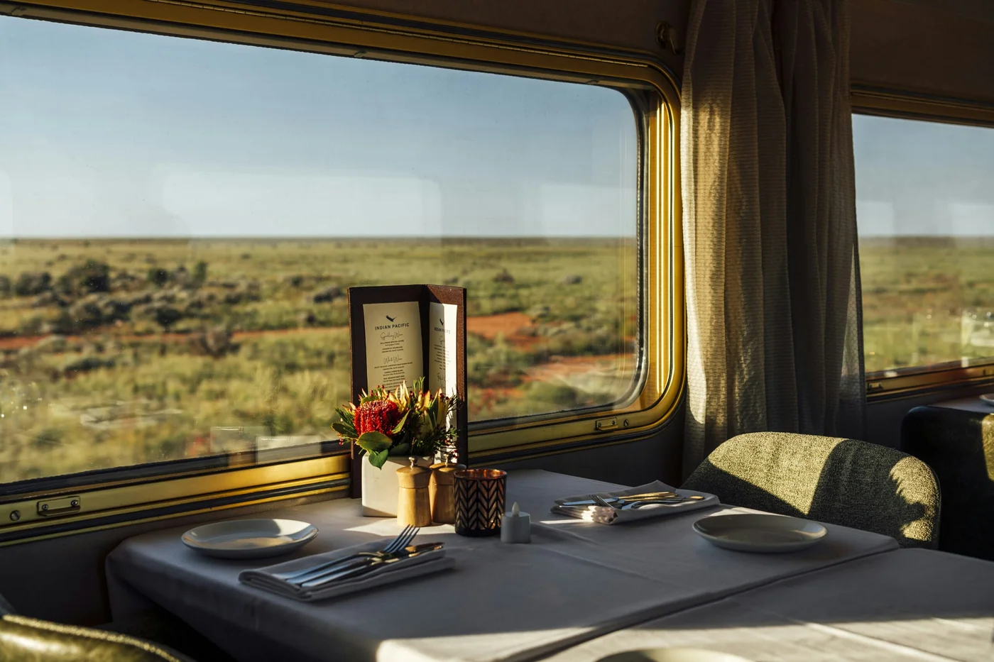 Table dressée dans le wagon-restaurant du Great Southern avec vue panoramique sur l'outback australien