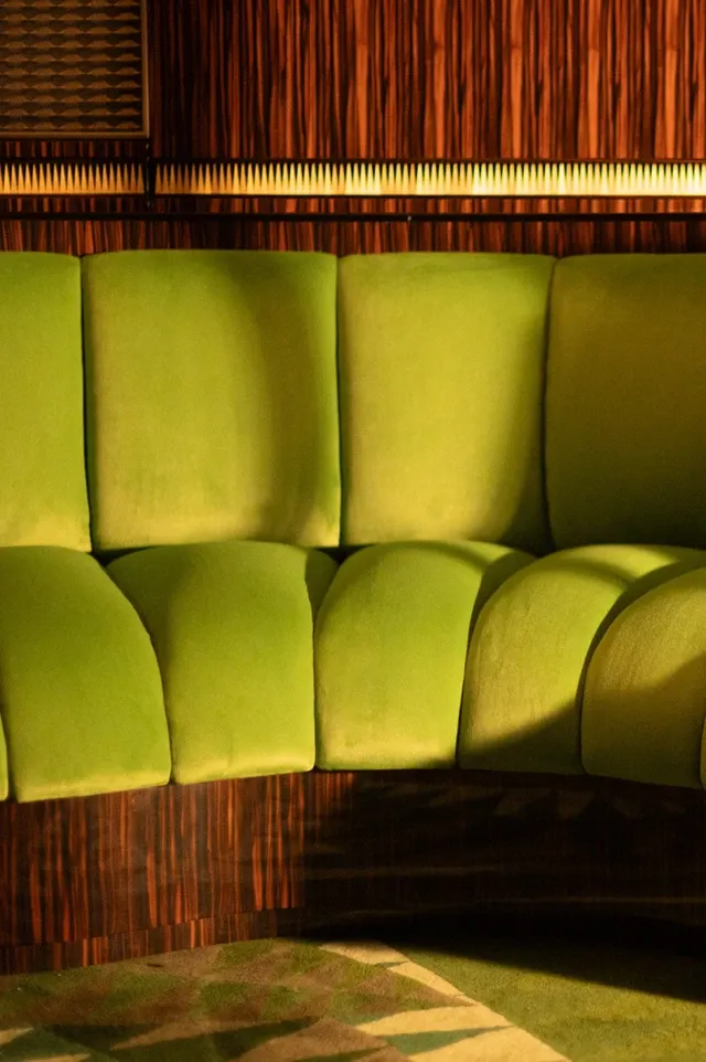 Sièges velours vert côtelé du wagon-bar de l'Orient Express 2027 — Ateliers Jouffre