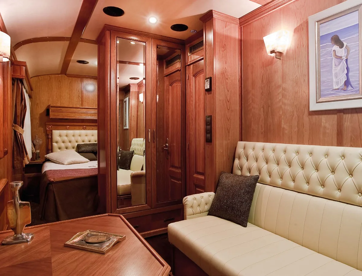 Suite Grand Deluxe Transcantábrico Gran Lujo avec boiseries en acajou et sofa en cuir capitonné