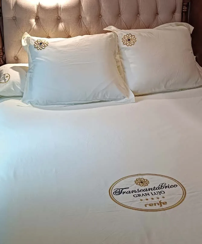 Détail du linge de lit brodé au monogramme Transcantábrico Gran Lujo Renfe