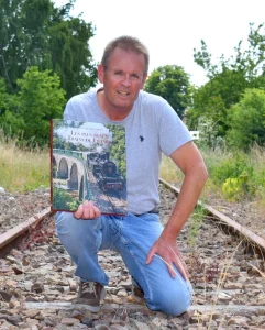 Auteur avec livre Les Plus Beaux Trains de France sur voie ferrée historique
