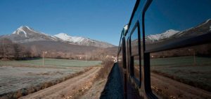 Expreso de la Robla train de luxe traversant vallée alpine avec montagnes enneigées